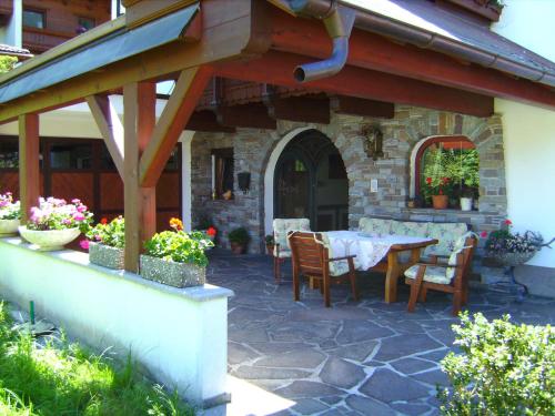 a patio with a table and chairs and a building at Pension Glockenstuhl in Finkenberg