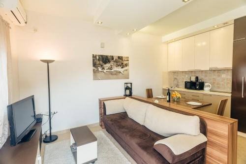 a living room with a couch and a kitchen at Beachfront Apartments Tivat in Tivat