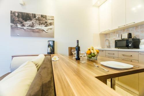 a kitchen with a wooden table in a room at Beachfront Apartments Tivat in Tivat