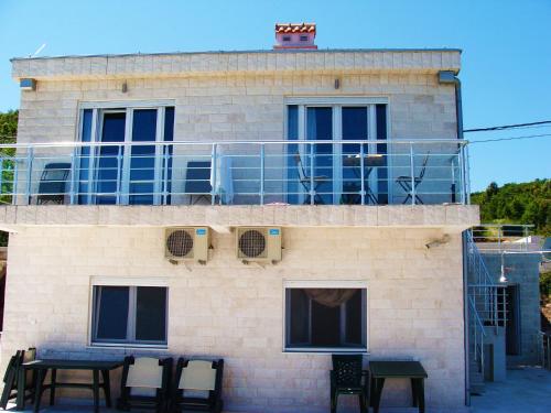 a building with tables and chairs in front of it at Beachfront Apartments Tivat in Tivat