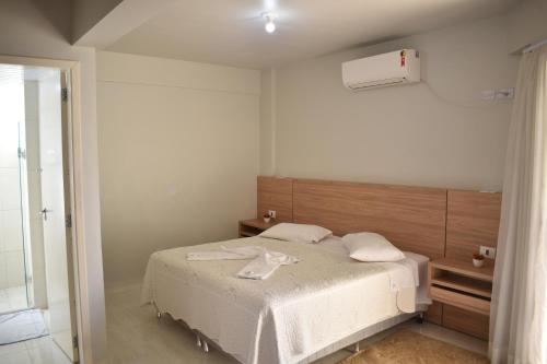 ein Schlafzimmer mit einem weißen Bett und einem Fenster in der Unterkunft Rai Hotel - By UP Hotel - próximo a Prefeitura in Cascavel