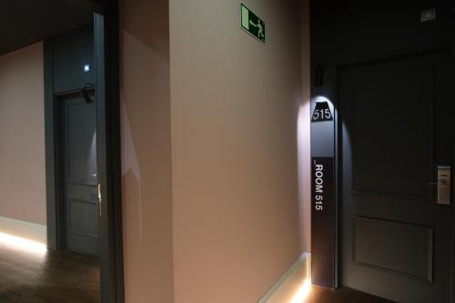 a hallway with a door and a sign on the wall at Petit Palace Triball in Madrid
