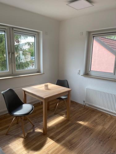 Habitación con mesa de madera y 2 sillas. en Boardinghouse-Heuchelhof, en Würzburg