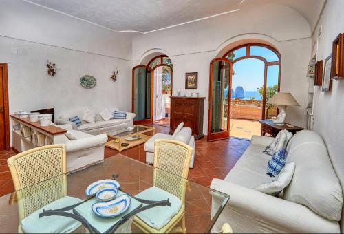 un soggiorno con divani, tavolo e sedie di Suite Casa Mia a Capri
