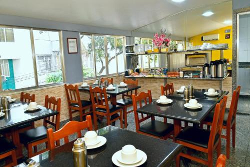 a restaurant with tables and chairs and a kitchen at Hotel Rio Claro in Rio de Janeiro