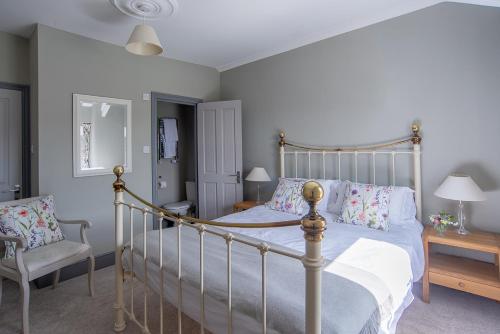 1 dormitorio con 1 cama y 1 silla en Dartmoor Inn, en Princetown