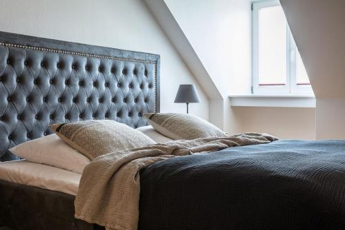 a bedroom with a large tufted bed with pillows at Schloss Harkensee in Dassow