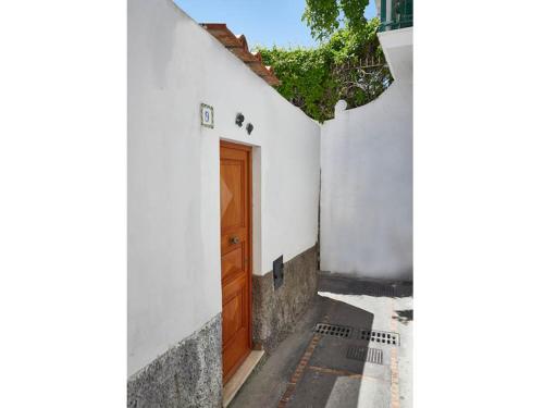 a white building with a wooden door on a street at Casa di Joe in Capri