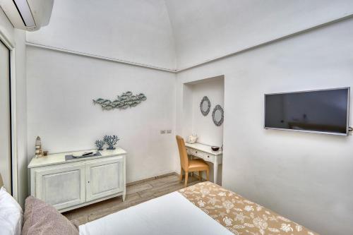 a bedroom with a bed and a desk and a tv at Casa di Joe in Capri