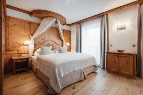 Una cama o camas en una habitación de Kolfuschgerhof Mountain Resort