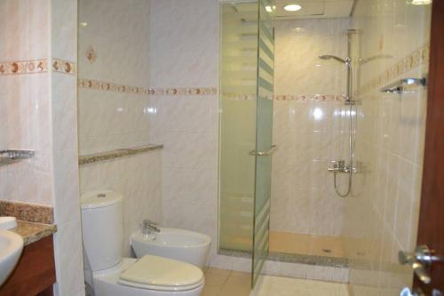 a bathroom with a shower and a toilet and a sink at Stunning Lake Views in Dubai JLT in Dubai