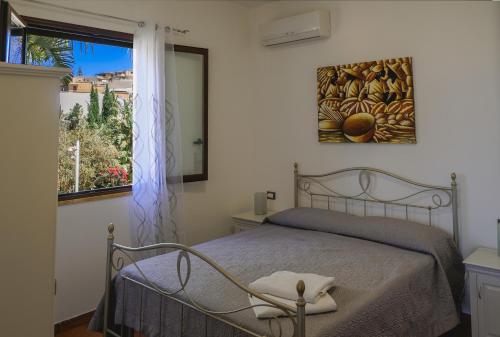 een slaapkamer met een bed en een raam bij Giardini Del Golfo in Balestrate
