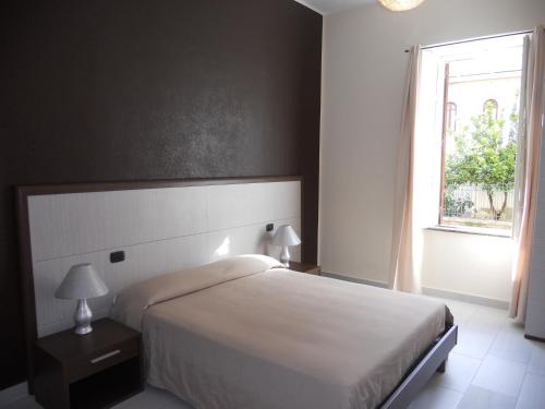 1 dormitorio con cama blanca y ventana en Sant'Agostino Affittacamere, en Reggio Calabria