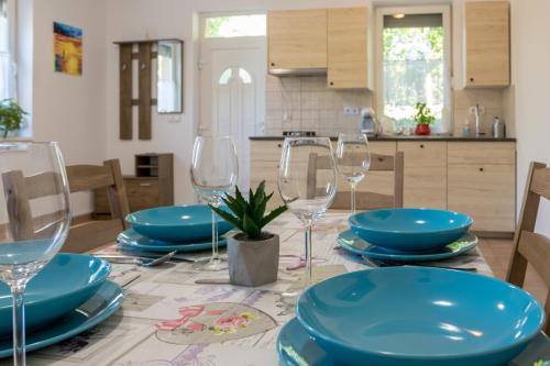 stół z niebieskimi talerzami i kieliszkami do wina w obiekcie #HelloCsopak w mieście Csopak