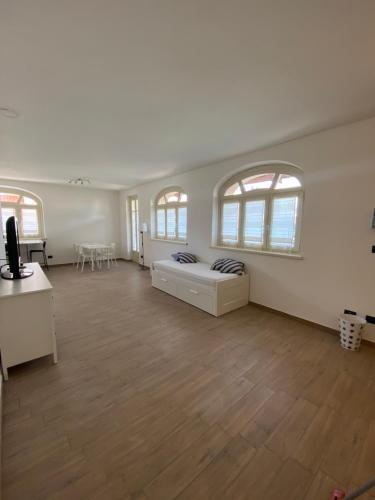 een grote kamer met een bed en 2 ramen bij Coronata 22 in Fossano