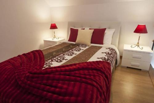 a bedroom with a large bed with a red blanket at Crystal House in Calheta