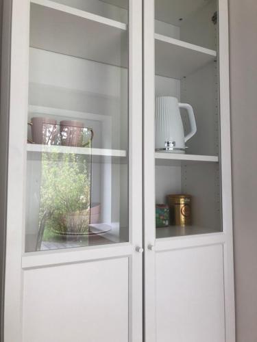 a white cabinet with a glass door at Kulautuva Park Apartments in Kulautuva