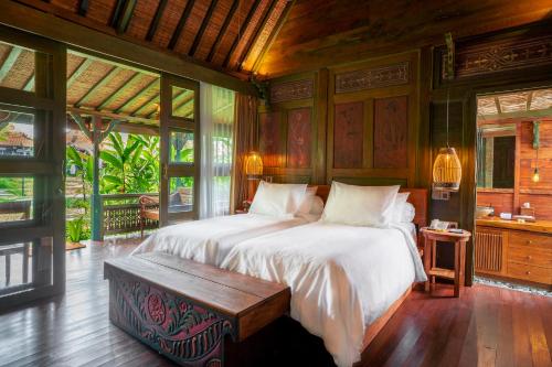 1 dormitorio con cama y banco. en Arya Arkananta Resort & Spa, en Ubud