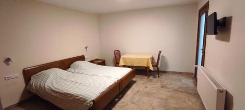 a small bedroom with a bed and a table at La Diligence in Arsdorf