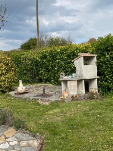 a stone oven in the middle of a yard at Maison 6 personnes La Tourelle in Saulchoy