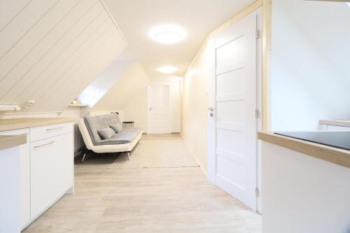 a kitchen with white cabinets and a couch at Pension Adel in Český Krumlov