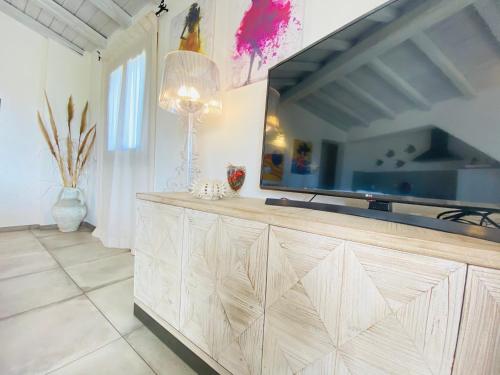 a living room with a large television on a wooden cabinet at Art Villa in San Teodoro