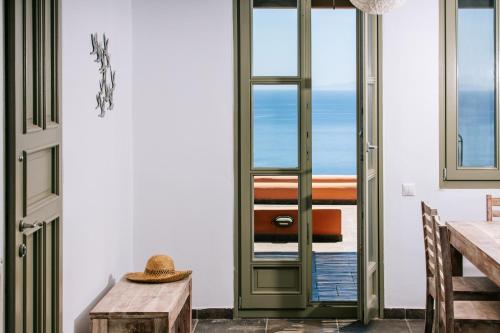 uma porta para uma sala de jantar com vista para o oceano em Front Row Seat to the Aegean by Neuvel em Ioulida