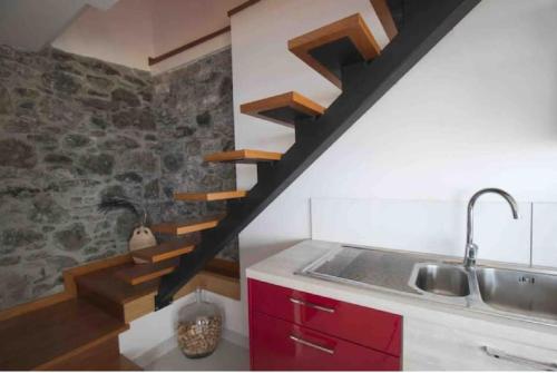 a kitchen with a sink and a wooden staircase at Crystal House in Calheta