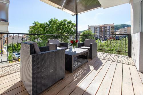 a patio with a table and chairs on a deck at Saki Apartments in Budva