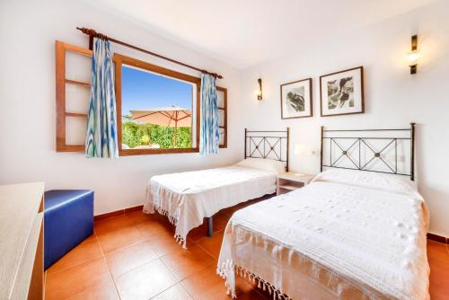 2 camas en una habitación con ventana en Can Amer en Pollença