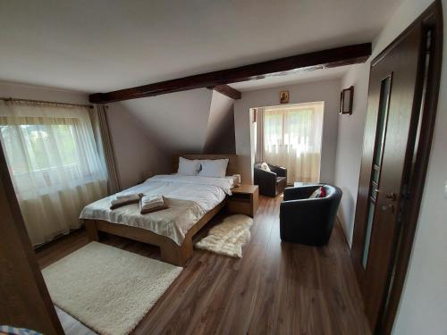 a small bedroom with a bed and a chair at Apartament Matei in Braşov