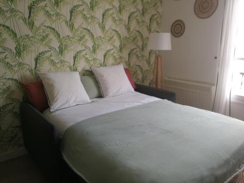 a bed with two pillows on it in a bedroom at We Sea in Deauville