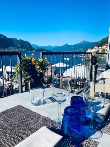a table with wine glasses and a view of the ocean at Hotel Villa Aurora in Lezzeno