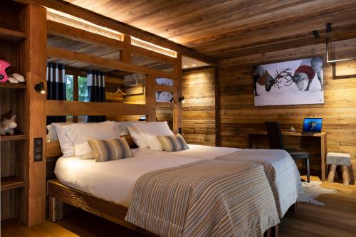 a bedroom with a large bed in a wooden room at Hotel Cote Brune in Les Deux Alpes