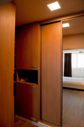 a closet with a glass door and a bed at 2 bedroom apartment close to center, park and shopping center in Chişinău
