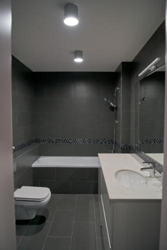 a bathroom with a sink and a tub and a toilet at 2 bedroom apartment close to center, park and shopping center in Chişinău