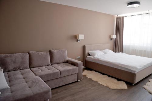 a bedroom with a bed and a couch at 2 bedroom apartment close to center, park and shopping center in Chişinău
