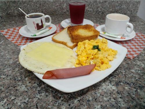 un piatto di prodotti per la colazione con uova, pane tostato e caffè di Finca Hotel Zona Franca a Rionegro