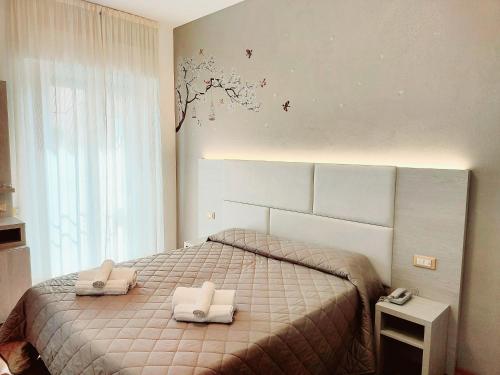 1 dormitorio con 1 cama con 2 toallas en Hotel Monica en Rímini