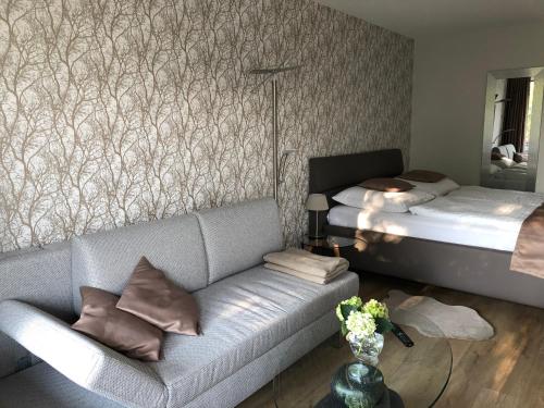 una sala de estar con un sofá y una cama en Appartement Ausblick Park, en Hahnenklee-Bockswiese