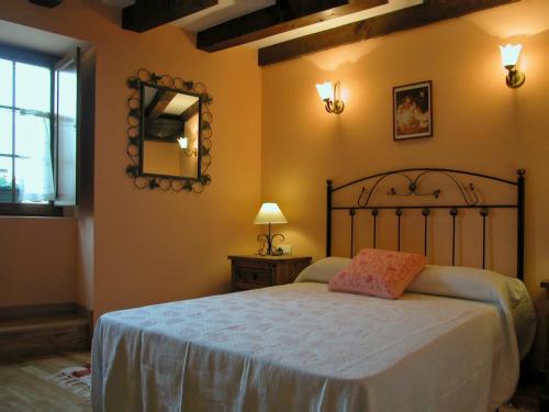 a bedroom with a large bed and a mirror at Casa Rural Juanserena by Clabao in Echarren