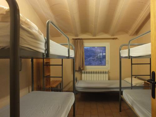 a room with three bunk beds and a window at Rectoria de Claverol in Claverol
