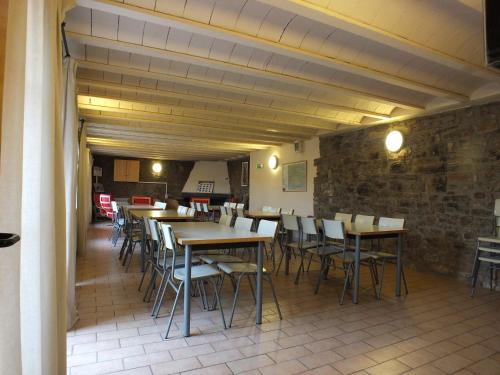 Rectoria de Claverol في Claverol: مطعم بطاولات وكراسي وجدار من الطوب