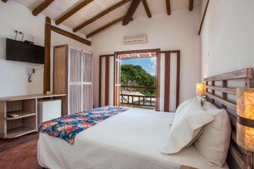 Un dormitorio con una cama grande y una ventana en Pousada Refugio da Harmonia, en Ilhabela
