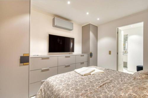 - une chambre avec un lit et une télévision murale dans l'établissement Somptueux logement,Cannes Croisette,4 Étoiles****, à Cannes