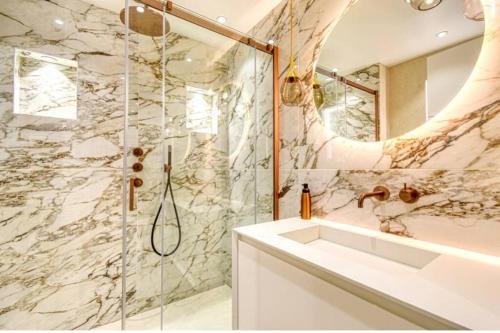 ein Bad mit einer Dusche und einem weißen Waschbecken in der Unterkunft Somptueux logement,Cannes Croisette,4 Étoiles**** in Cannes