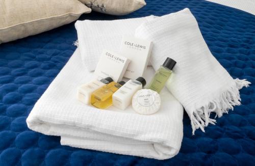 a pile of towels and cosmetics on a bed at The White House By Select SA in Reading