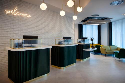 a lobby with a row of counters and chairs at Leonardo Hotel Bristol City in Bristol