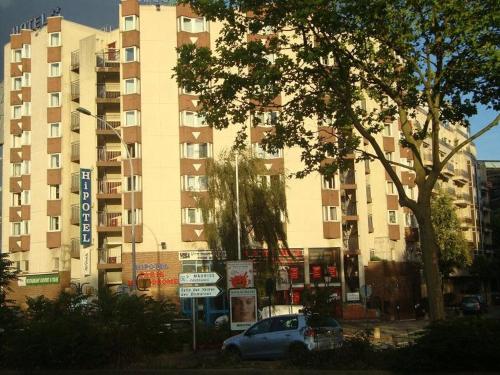 a car parked in front of a tall building at Hotel Joinville Hippodrome in Joinville-le-Pont