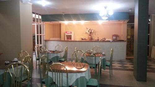 a dining room with tables and chairs and a counter at Hotel Luxor in Cochabamba